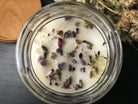 soy candle topped with crystals and herbs
